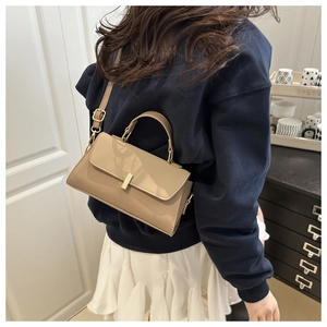 Close-up of khaki PU leather crossbody bag featuring a golden metal buckle and top handle