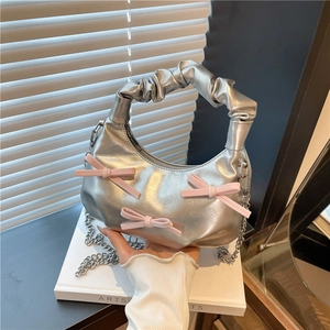 Silver metallic hobo bag with pink bows and ruched handle shown from a front angle