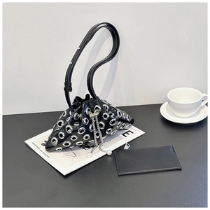 Detail of black punk bucket bag with silver metal eyelets and pearl drawstring charms