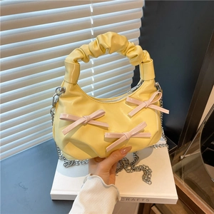 Glossy yellow PU handbag with pink bows, ruffled handle and silver chain strap