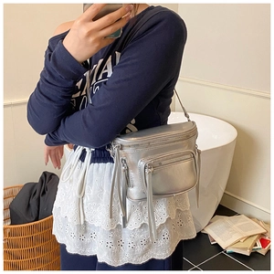 Détails du sac demi-lune argenté métallisé avec longues franges et fermetures éclair
