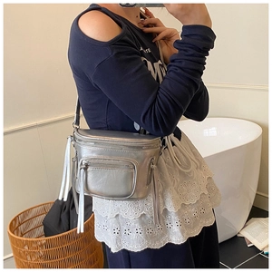 Détail du sac bandoulière argenté métallisé avec franges et poche zippée avant