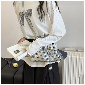 Close-up of silver studded bucket bag with chain drawstring and pearl detail