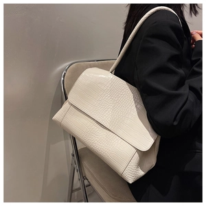 Elegant ivory faux crocodile leather shoulder bag shown on model in a minimalist setting