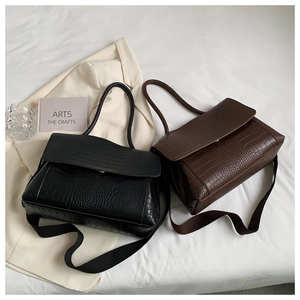 Close-up of elegant crocodile pattern leather handbags in black and deep brown colors