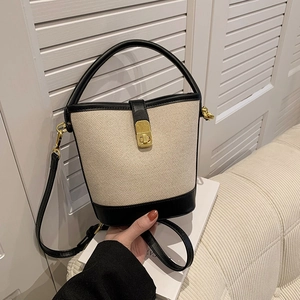 Chic two-tone canvas bucket bag with black leather trim and gold twist lock closure