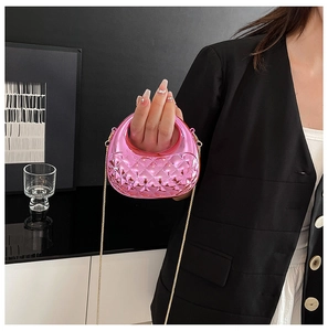 Detail of bright pink metallic crossbody bag with diamond quilting and gold chain