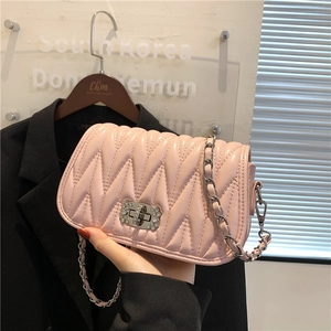 Pink quilted leather crossbody bag with V-shaped stitching and metal chain strap