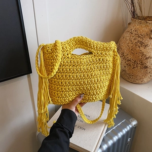 Gelbe Boho-Stofftasche mit Fransen und geflochtenen Griffen in einem Lifestyle-Ambiente
