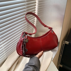 Chic red crescent moon shoulder bag with glossy finish and heart key charm detail