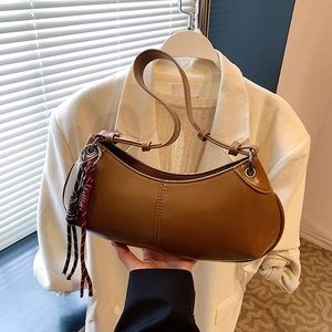 Brown half-moon underarm bag in sleek PU leather with a decorative woven tassel