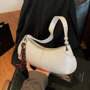 Minimalist white leather moon bag with decorative key charm for women as a crossbody bag