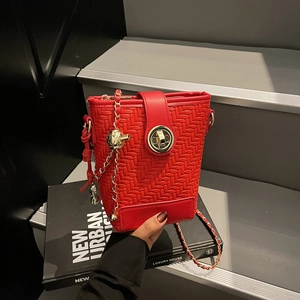 Fashionable red woven bucket bag with gold chain strap and metal sphere charm