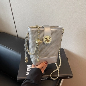 Silver woven bucket bag with chain strap and metallic finish for modern fashion style