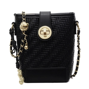 Chic black woven bucket bag with gold chain strap and animal charm on white background