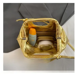 Internal capacity of the gold pleated cloud clutch bag showing spacious storage space