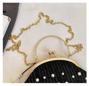 Détail du sac plissé noir à perles avec cadre doré et bandoulière chaîne amovible