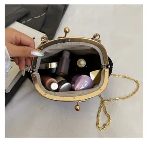 Détail d'un sac de soirée plissé noir montrant son intérieur spacieux pour maquillage et chaîne