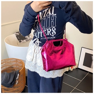 Detailed view of pink metallic crossbody bag with cut-out handle and slim strap