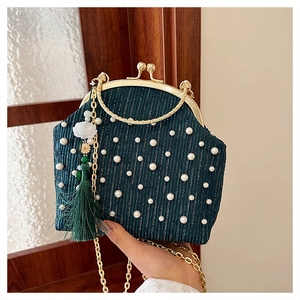 Détail du sac à main plissé vert avec perles, fermoir doré et pendentif à franges