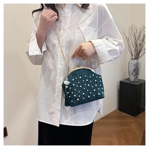 Détail du sac de soirée plissé émeraude avec perles, poignée en métal et glands en soie