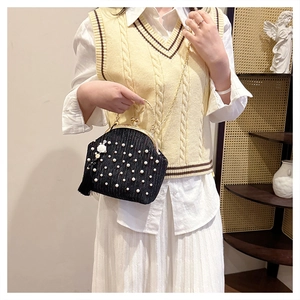 Détail du sac de soirée plissé noir avec fausses perles et chaîne en métal doré