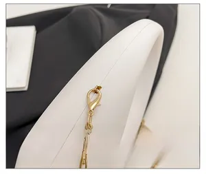 Close-up detail showing the high-quality gold hardware and chain on a white acrylic bag