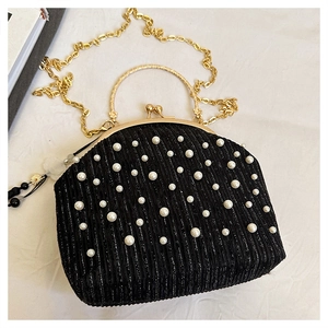 Détails d'un sac de soirée noir élégant orné de perles et d'une poignée dorée