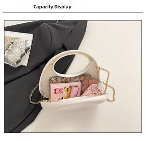 White acrylic crescent evening bag interior showing capacity for phone and cosmetics