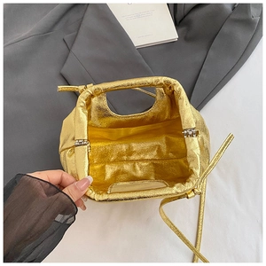 Detail view of gold metallic cloud bag with gathered leather texture and spacious interior