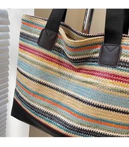 Close-up of colorful striped woven straw tote bag with black durable canvas handles