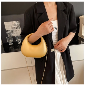 Détail du sac hobo en croissant jaune vif avec une bandoulière en chaîne dorée brillante