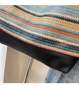 Detail of colorful woven tote bag with durable black leather bottom and fine stitching