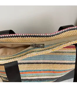 Detail of a colorful striped woven tote bag featuring a smooth metal zipper closure