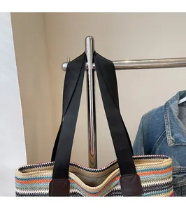 Detail of bohemian striped woven tote bag featuring wide black fabric shoulder straps