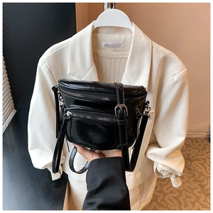 Détail du sac à bandoulière en cuir noir brillant avec plusieurs fermetures éclair argent