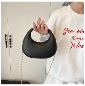 Pochette demi-lune noire chic en acrylique avec chaîne dorée amovible tenue par mannequin