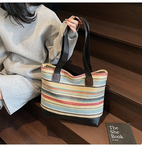 Detail of colorful striped woven tote bag with durable black base and handles
