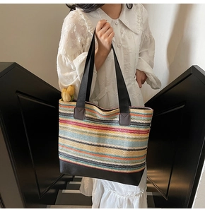 Close-up of a colorful woven tote bag featuring vibrant stripes and durable leather straps