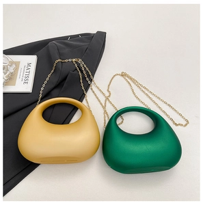 Détail de sacs à main en acrylique jaune et vert foncé avec chaîne dorée et anse