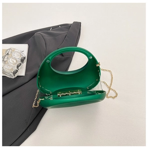 Détail de la pochette en acrylique vert émeraude avec charnière dorée et bandoulière