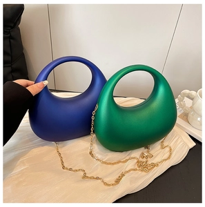 Détail de pochettes de soirée en acrylique en forme d'œuf vert émeraude et bleu royal