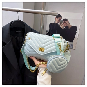 Close-up of mint blue V-quilted crossbody bag with gold twist lock and mini coin purse