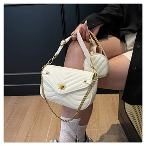 Close-up of white quilted crossbody bag with gold hardware and a small round coin purse