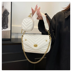 Detail of white V-quilted faux leather crossbody bag with wide strap and round coin purse