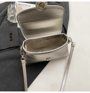 Detailed view of silver metallic textured crossbody bag with magnetic closure and lining