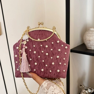 Sac à main élégant orné de perles rose poudré avec finitions dorées et détail de gland