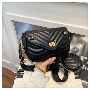 Detail of black chevron quilted shoulder bag with gold turn-lock and mini coin purse
