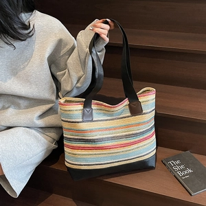 Colorful striped woven tote bag with durable black handles for a casual summer style