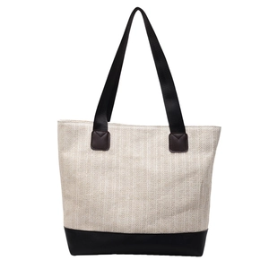 Minimalist beige woven tote bag with contrasting black leather straps and base